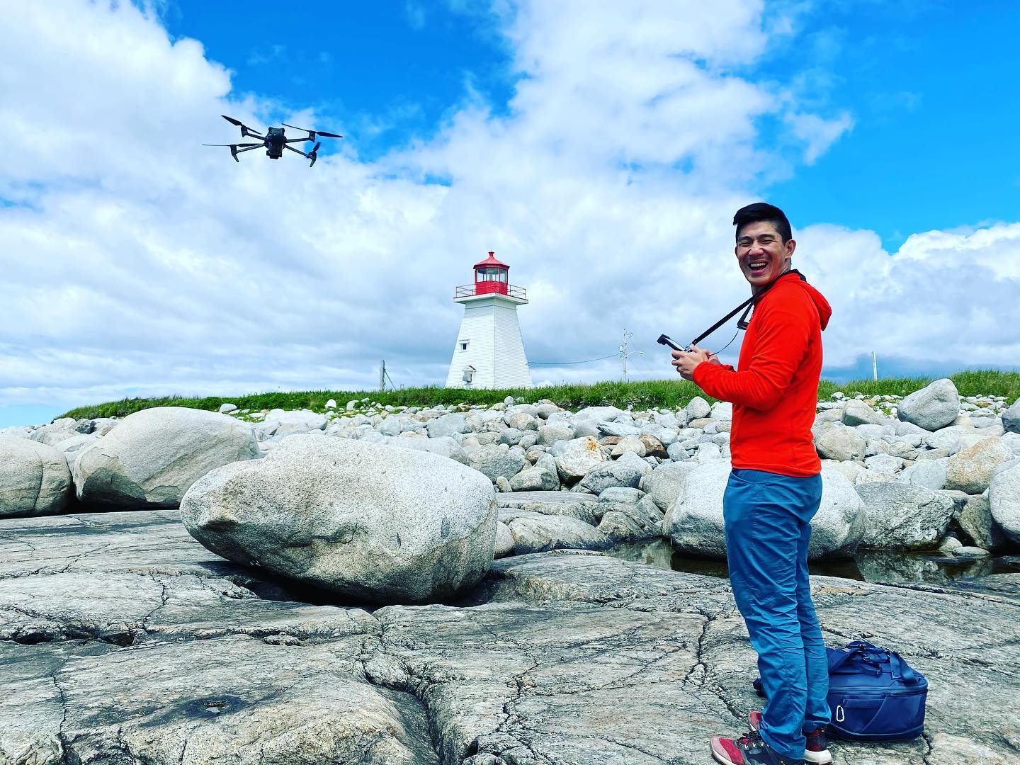 Man flying a drone at a lighthouse.